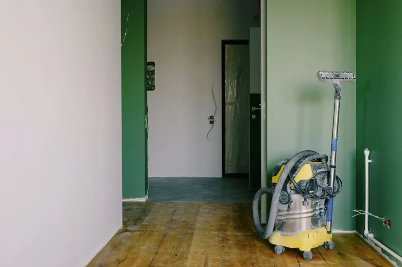 Industrial vacuum standing in an empty room with green walls